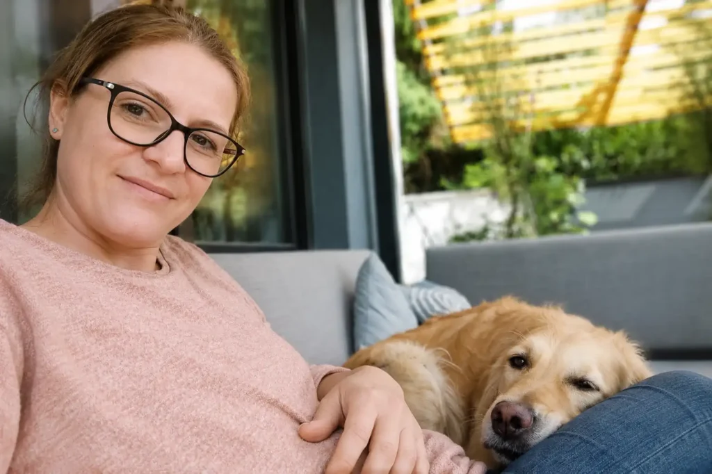 Ella, Gründerin von Kleine Stiche, mit ihrem Hund auf der Terrasse.